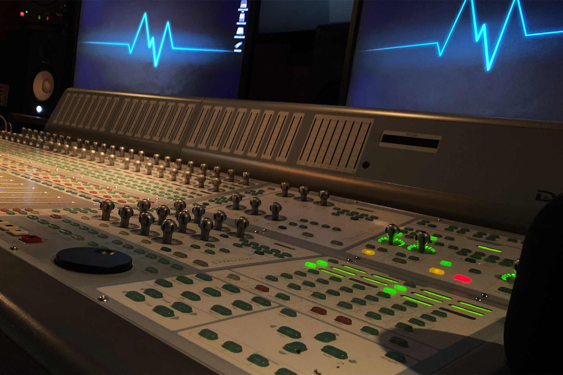 man watching a band on the stage wearing a red t-shirt and black hat.