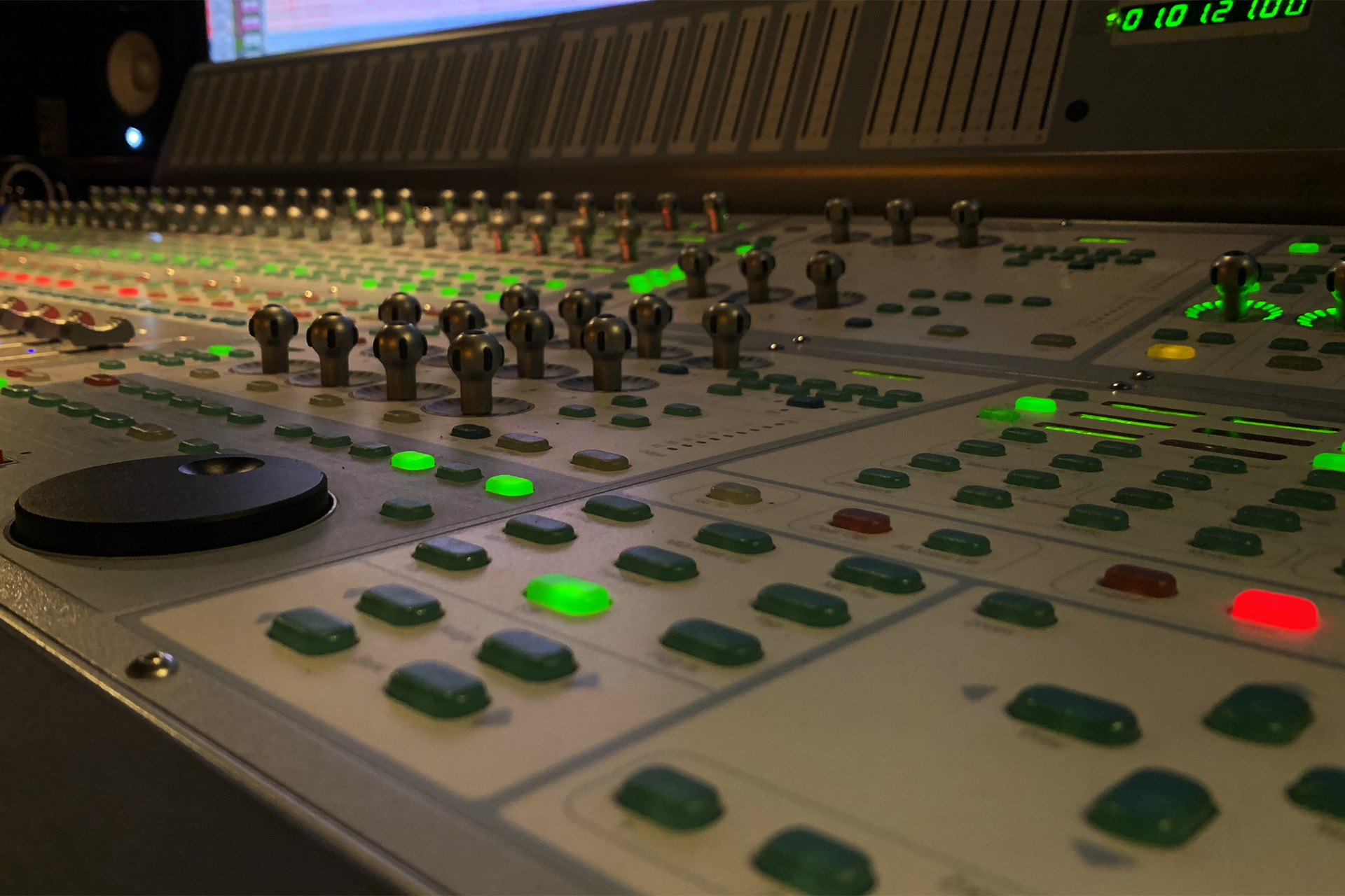 Back of a man at a concert. Hes wearing a beanie hat and a baggy denim jacket with studs. Photo with a purple hue