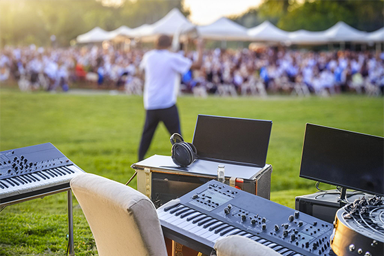 Back of a man at a concert. Hes wearing a beanie hat and a baggy denim jacket with studs. Photo with a purple hue
